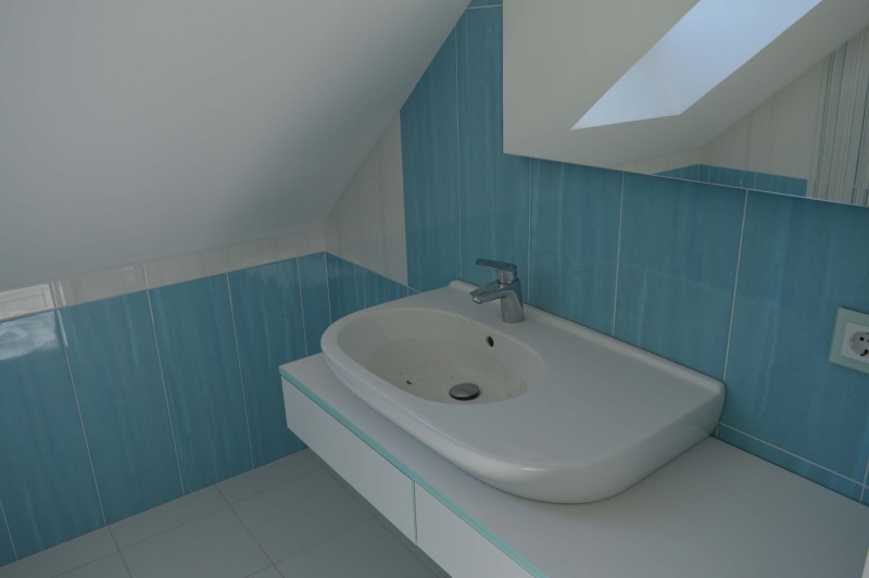 Облицовка ванной комнаты на мансардном этаже в бело-голубых тонах